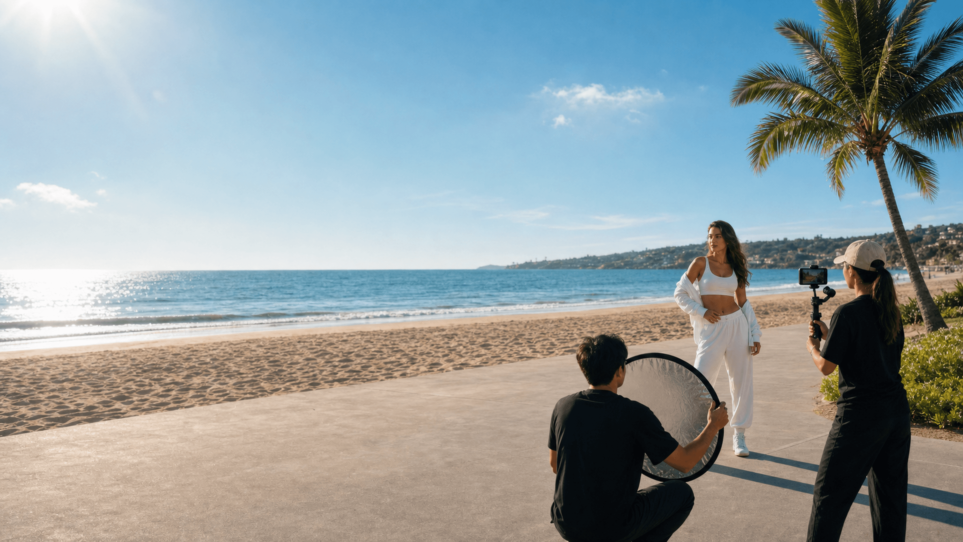 A sunny beach production scene with a creator, camera team, and product shooting setup.